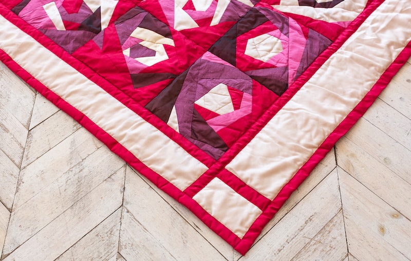 modern quilt pattern blanket on a wooden floor