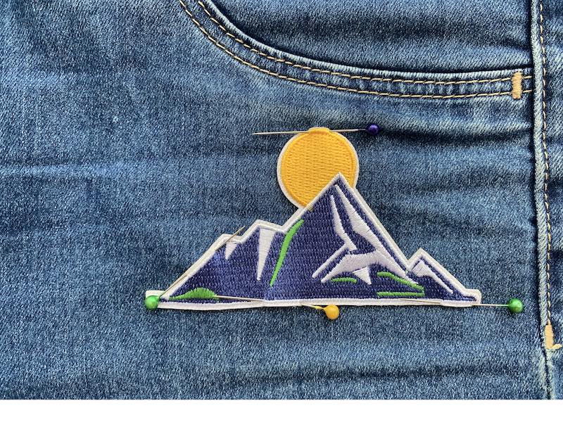 Patch pinned to the denim fabric with sewing pins