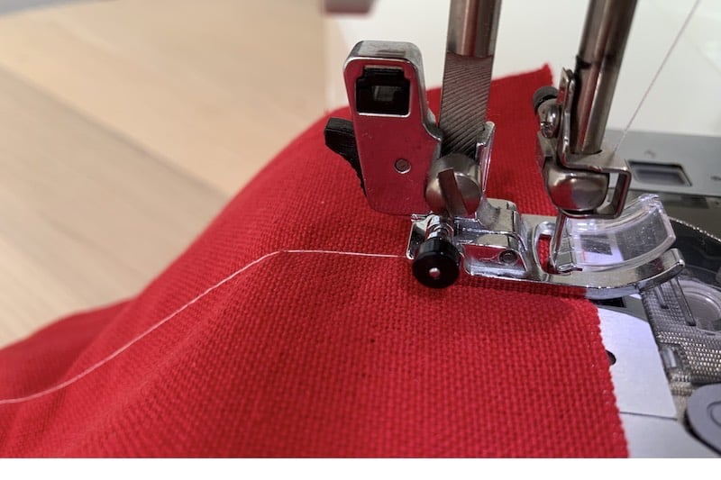 stitching with a sewing machine on a red fabric