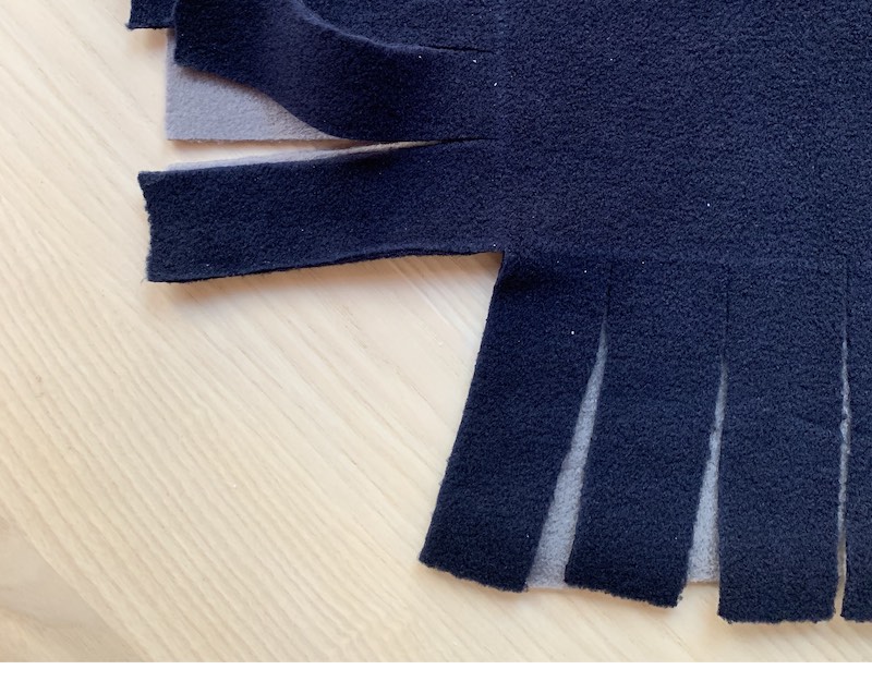 fringes cut out on two sides of a fleece fabric