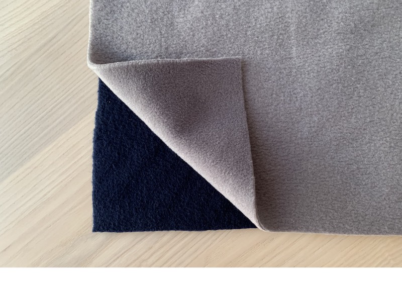 two pieces of fleece fabric on a wooden table