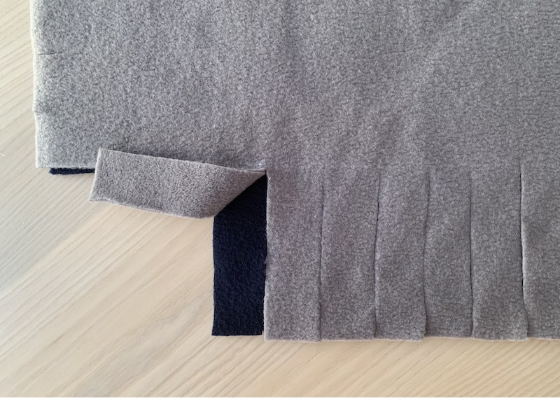 a piece of fleece fabric with fringes cut out on one side
