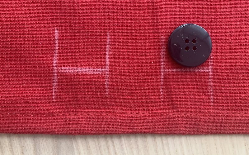 button placed on a piece of fabric and marked with a chalk