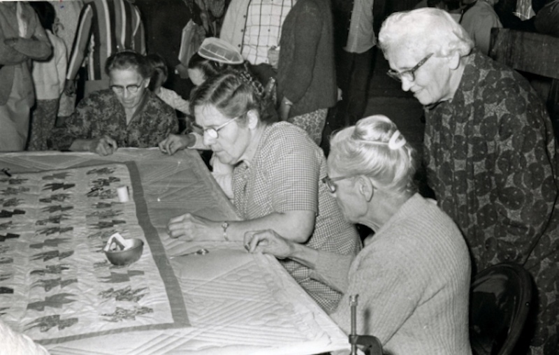 an old photograph of women quilting