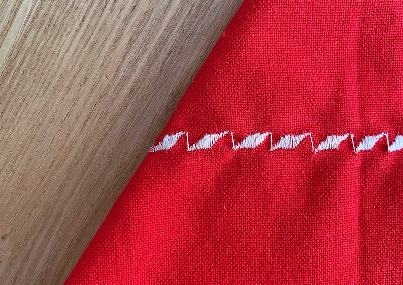 a red piece of fabric with white embroidery