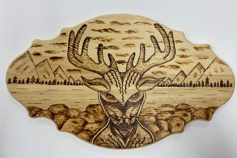 a wooden plaque with a pyrography design